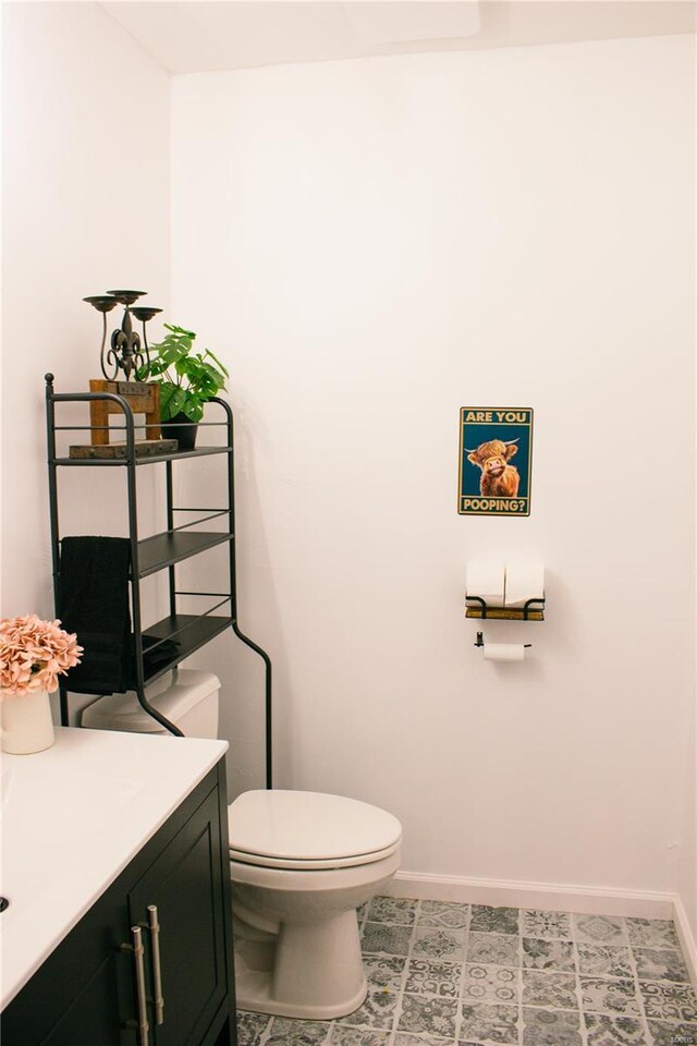 bathroom with vanity, toilet, and baseboards