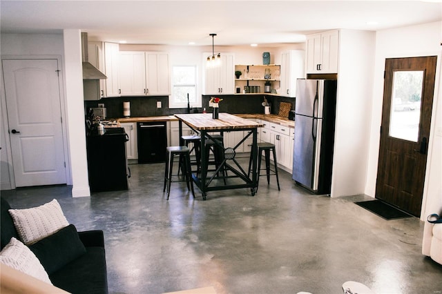 kitchen with freestanding refrigerator, white cabinetry, wall chimney exhaust hood, and dishwasher