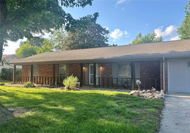 single story home featuring a front yard, a porch, brick siding, and a garage