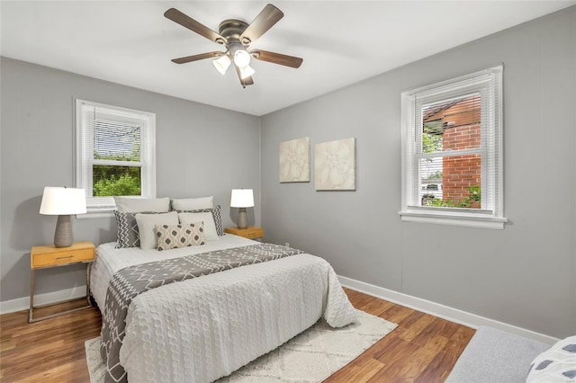 bedroom with ceiling fan, baseboards, and wood finished floors