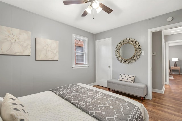 bedroom with baseboards, a ceiling fan, and wood finished floors