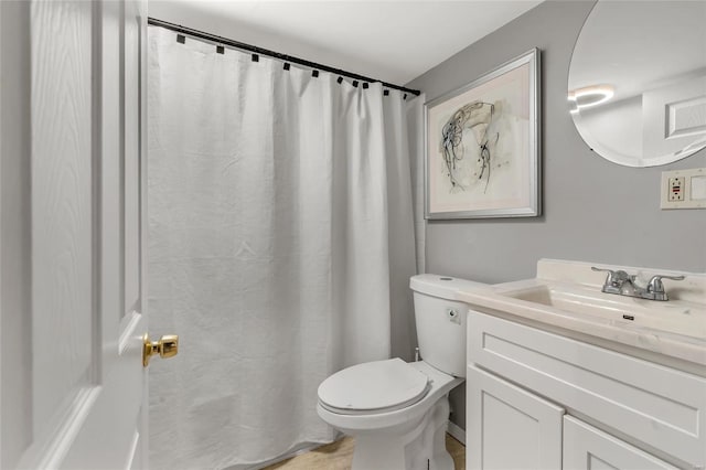 full bath with curtained shower, vanity, and toilet