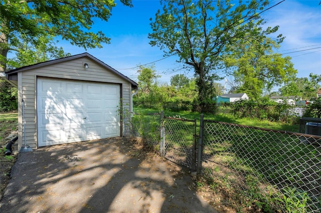 detached garage featuring aphalt driveway and fence