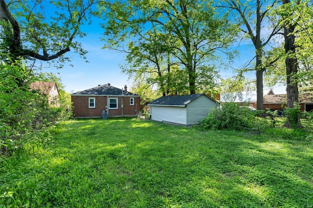view of yard featuring a shed, fence, and an outbuilding