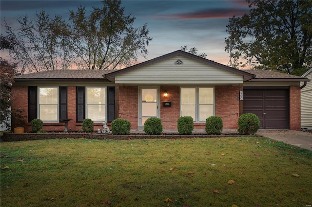 ranch-style home featuring a lawn, driveway, brick siding, a garage, and a shingled roof