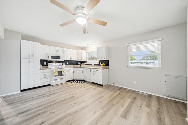 kitchen featuring white appliances, visible vents, light wood-style flooring, white cabinetry, and a ceiling fan