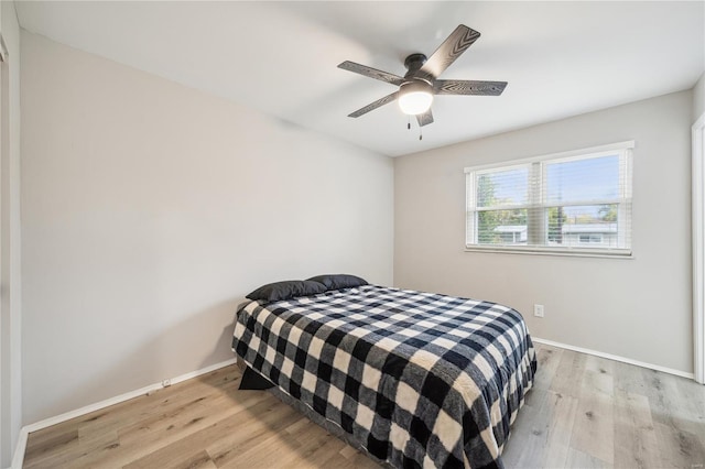 bedroom with baseboards, a ceiling fan, and wood finished floors