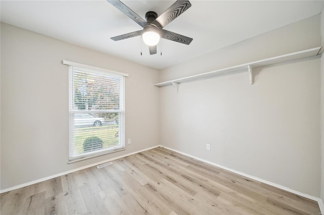 empty room featuring baseboards, a ceiling fan, visible vents, and light wood-style floors