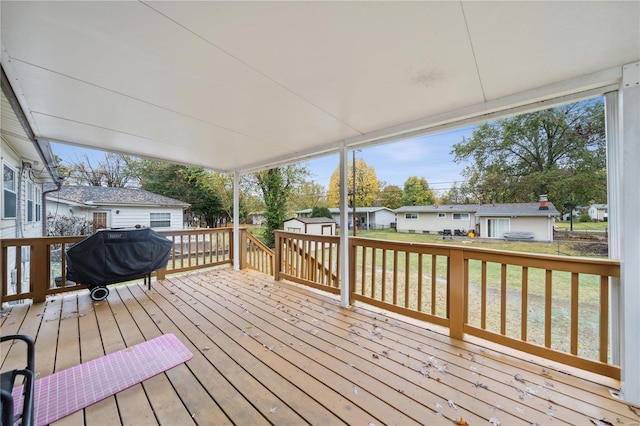 wooden terrace with a residential view, area for grilling, an outdoor structure, a shed, and a yard