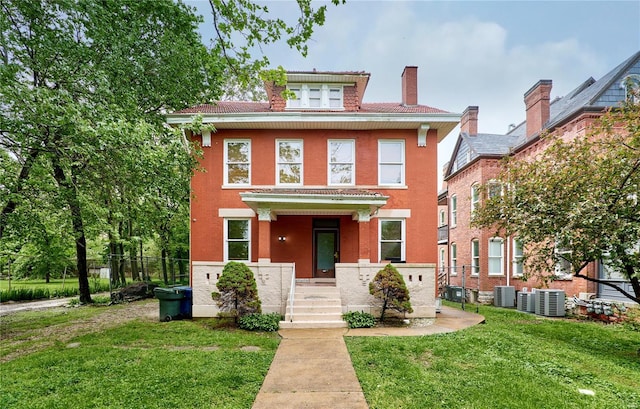 traditional style home with a chimney, a front yard, cooling unit, and fence
