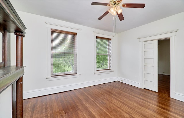 interior space featuring dark wood-type flooring, baseboards, and a ceiling fan