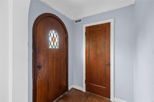 entryway featuring baseboards, dark wood-type flooring, visible vents, and arched walkways