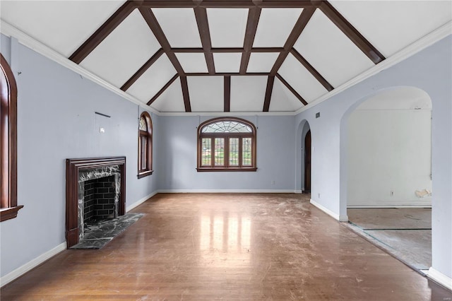 unfurnished living room featuring arched walkways, baseboards, a high end fireplace, and high vaulted ceiling