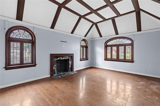unfurnished living room featuring a high end fireplace, wood finished floors, high vaulted ceiling, beamed ceiling, and baseboards