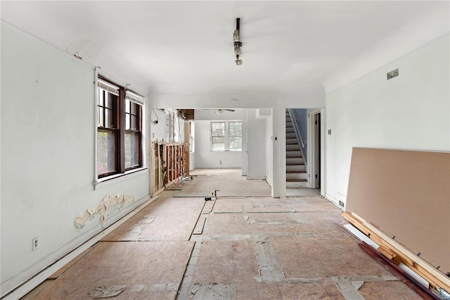empty room with a ceiling fan, stairs, and visible vents