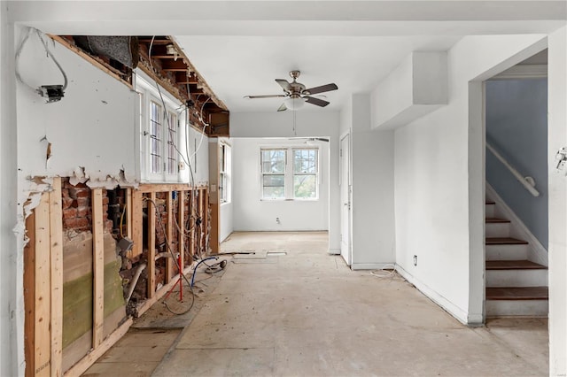 interior space featuring ceiling fan and stairs