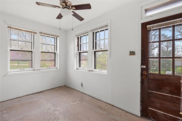 entrance foyer featuring plenty of natural light, concrete flooring, and a ceiling fan