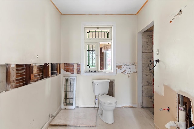 bathroom with ornamental molding, baseboards, and toilet