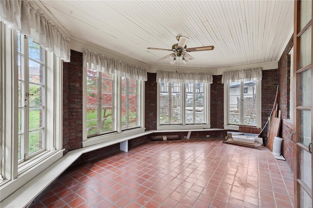 unfurnished sunroom featuring brick wall, tile patterned flooring, and wooden ceiling