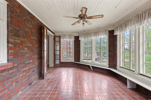 unfurnished sunroom with ornamental molding, tile patterned floors, brick wall, and wood ceiling