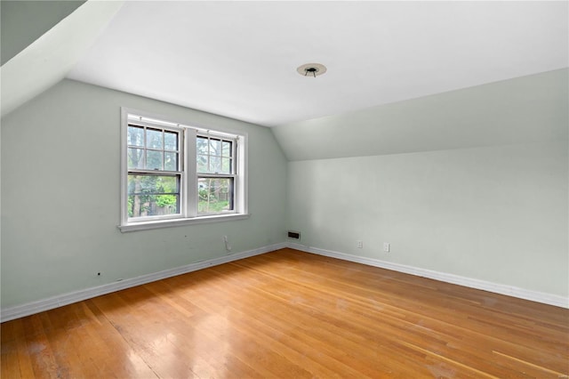 bonus room featuring vaulted ceiling, baseboards, visible vents, and light wood-style floors