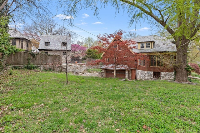 view of yard with an attached garage and fence