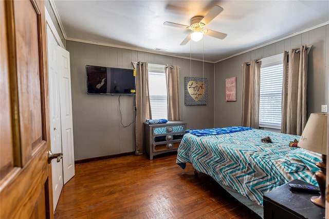 bedroom featuring wood-type flooring, visible vents, baseboards, ceiling fan, and ornamental molding