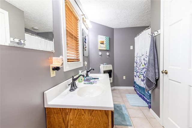 full bathroom featuring heating unit, a sink, a textured ceiling, tile patterned flooring, and baseboards