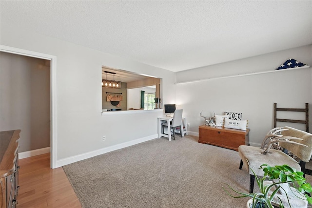 interior space with baseboards, a textured ceiling, and wood finished floors