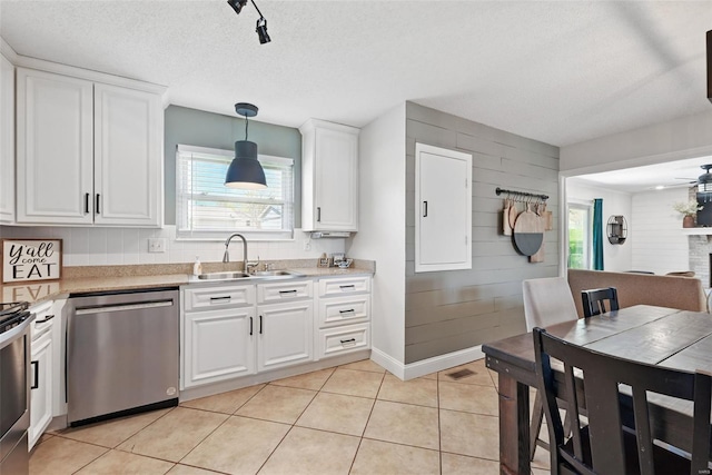kitchen with a sink, white cabinetry, light countertops, and dishwasher