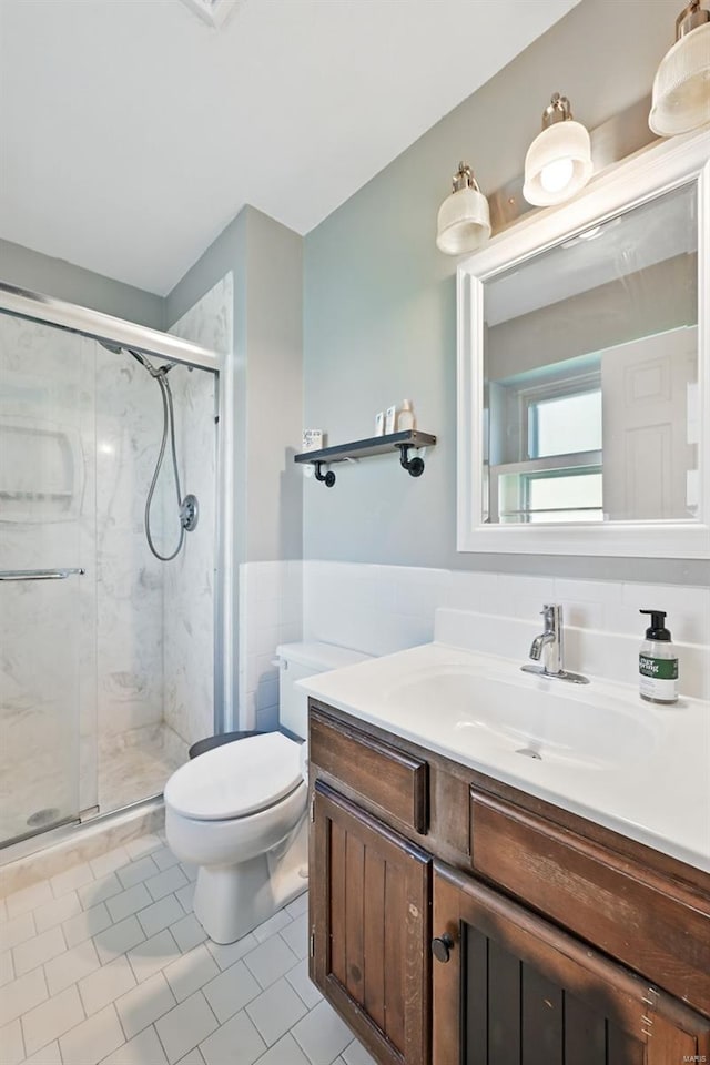 full bath featuring toilet, wainscoting, a shower stall, tile patterned floors, and vanity