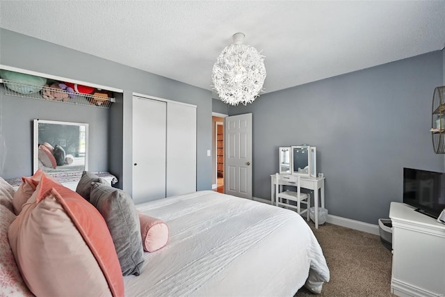 bedroom featuring a closet, baseboards, carpet floors, and a notable chandelier