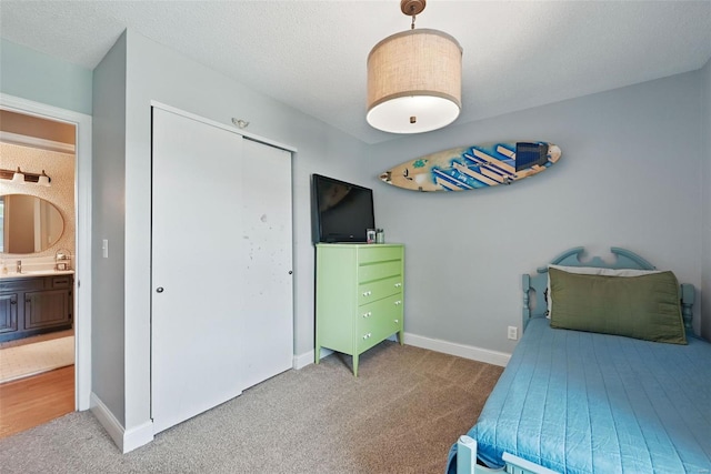 carpeted bedroom with baseboards and a closet