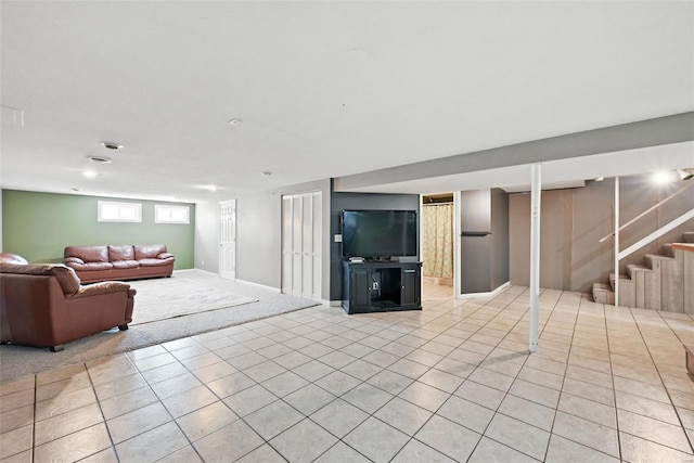 living room with light tile patterned floors, stairs, and baseboards