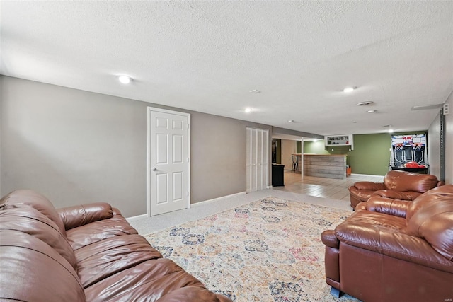 living area with a textured ceiling and baseboards