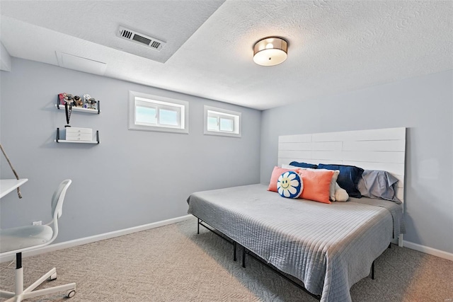 carpeted bedroom featuring baseboards, visible vents, and a textured ceiling