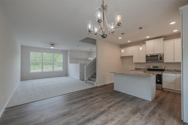 kitchen featuring baseboards, stainless steel appliances, open floor plan, and recessed lighting