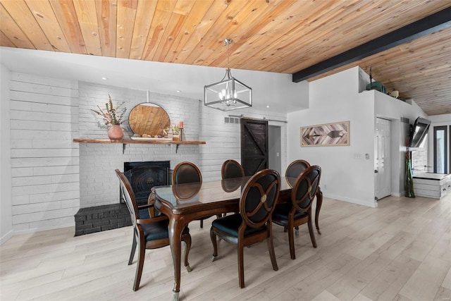 dining area with baseboards, wood ceiling, a fireplace, light wood finished floors, and a chandelier
