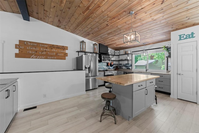 kitchen with appliances with stainless steel finishes, open shelves, wood ceiling, wood counters, and lofted ceiling