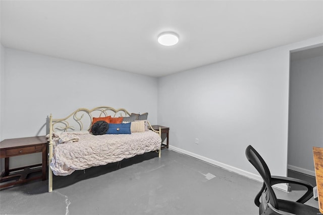 bedroom with concrete flooring and baseboards
