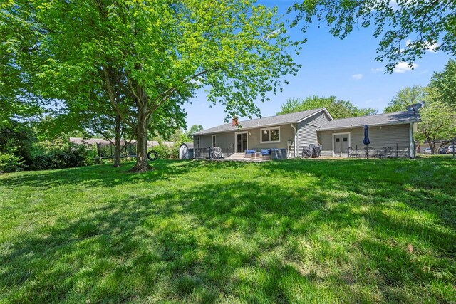view of green lawn with a patio area