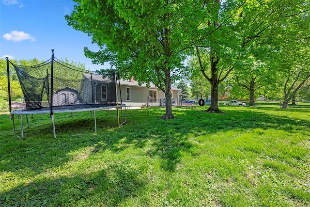 view of grassy yard featuring a trampoline