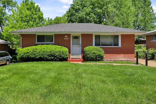 single story home featuring a front yard, brick siding, and a shingled roof