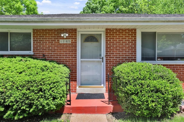 view of exterior entry with brick siding