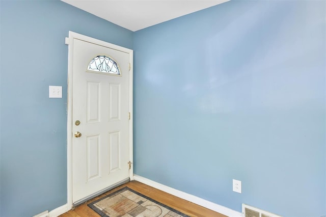 foyer featuring wood finished floors and baseboards