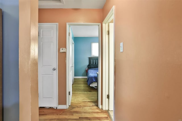 hall featuring light wood-style floors and baseboards