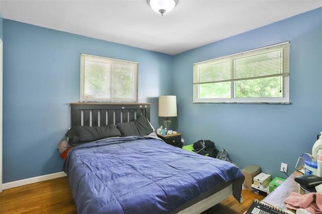 bedroom featuring wood finished floors and baseboards