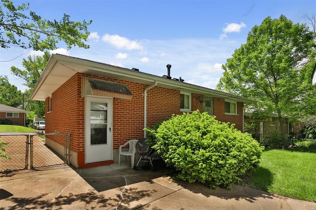 view of front of property featuring a gate, brick siding, and fence