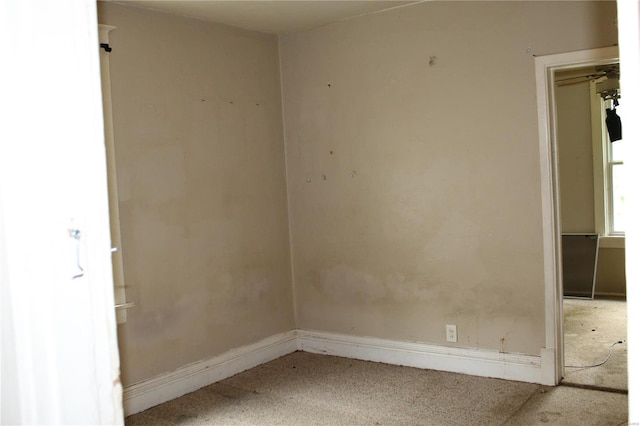 carpeted empty room featuring baseboards
