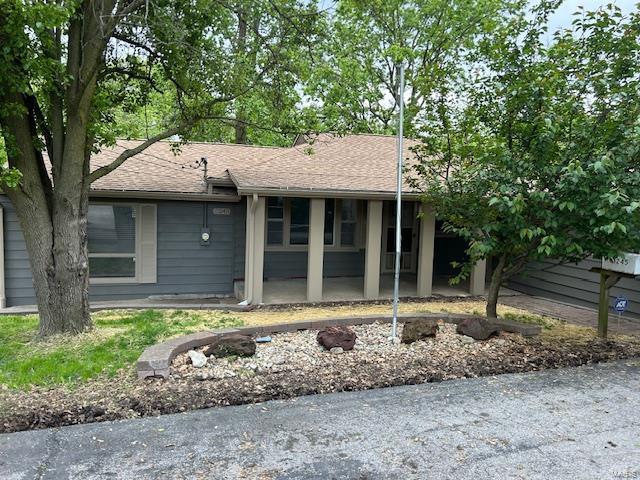 ranch-style house with a porch and a shingled roof